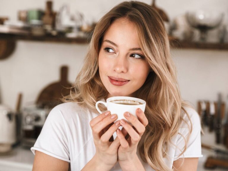 Kobieta z kawą. Obrazek w artykule Ból brzucha po kawie z mlekiem. Jakie są możliwe przyczyny i sposoby zaradzenia?