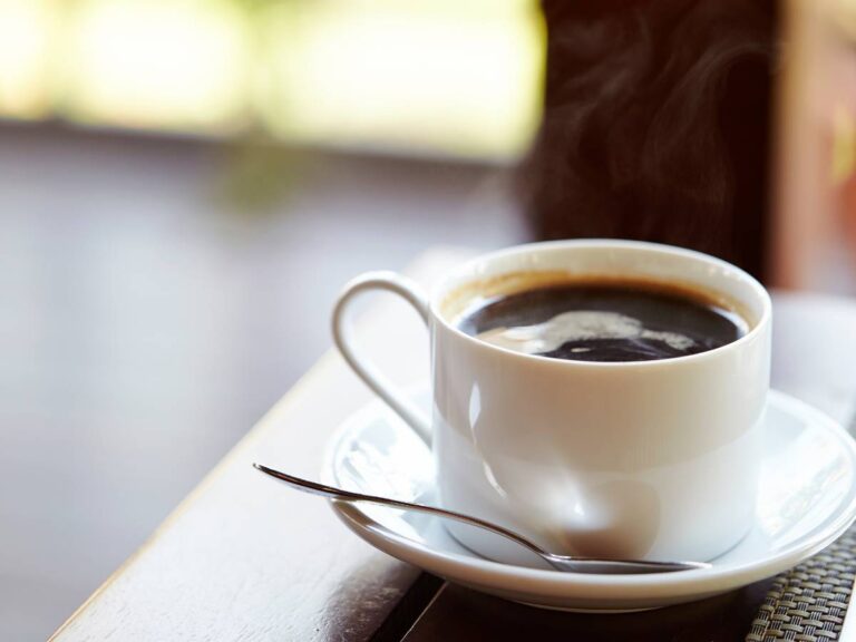 Filiżanka kawy na stole. Obrazek w artykule Czy kawa bezkofeinowa jest zdrowa? Wyjaśniamy zdrowotne właściwości