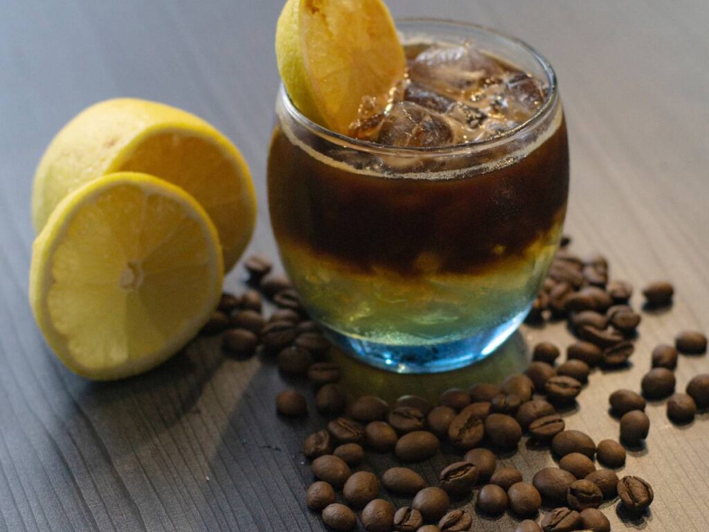 Szklanka z kawą i cytryną. Obrazek w artykule Kawa z cytryną. Jak smakuje kawa z dodatkiem cytryny?