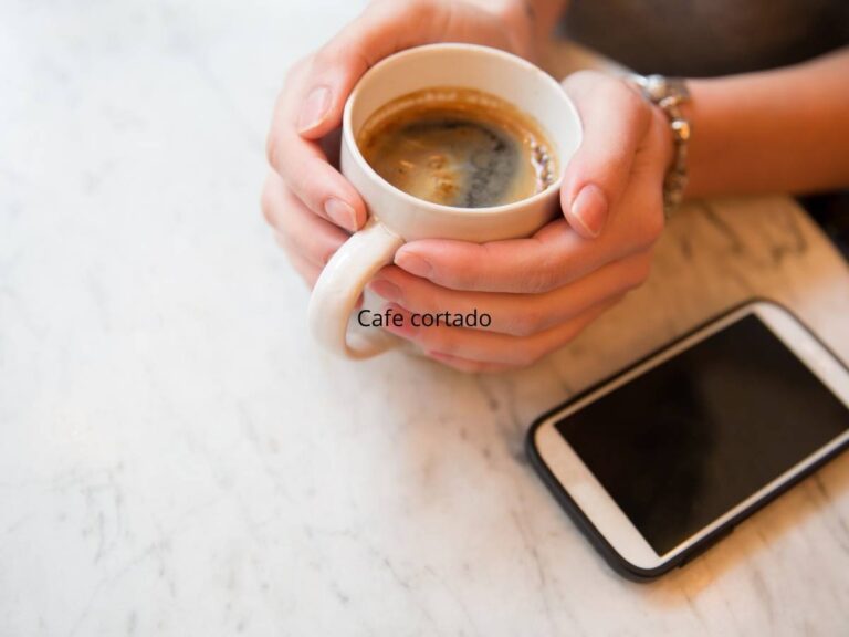 Filiżanka kawy i smartfon na stole. Obrazek w artykule Czy kawa podnosi cukier we krwi? Fakty i mity o kawie